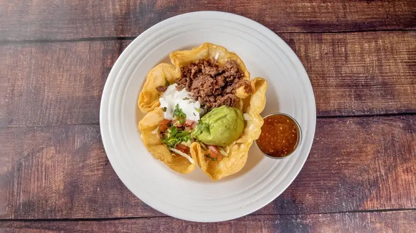 Tostada bowl with meat, guacamole and salsa